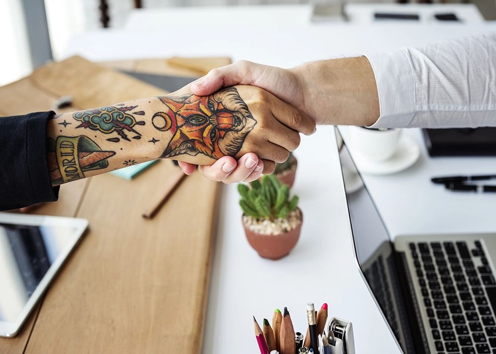 Poignée de main créative tatouage partenariat identité visuelle